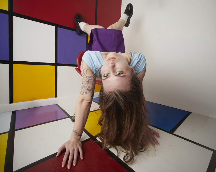 Model posing against colorful Mondrian-style geometric wall, creative editorial photography by Motor City Moda