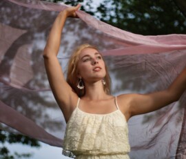 Rotary Park Livonia Michigan Outdoor Fashion Photography Fashion portrait of woman in white lace dress raising pink flowing fabric overhead among trees at Rotary Park Livonia Michigan