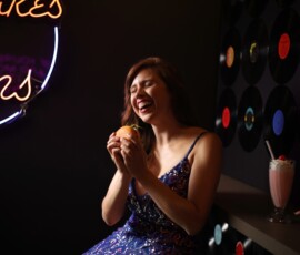 Joyful Retro Diner Fashion Photography — Grand Rapids Michigan Joyful fashion portrait of woman in blue sequin gown laughing with burger and milkshake at retro diner neon sign Grand Rapids Michigan