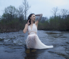 Dynamic Editorial Fashion Photography — Detroit Metro Michigan Dynamic editorial outdoor fashion portrait woman soaking white boho dress rose tattoo sleeve hand behind head dress flowing current Detroit Metro Michigan