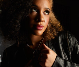 Dramatic Close Up Fashion Portrait — Traverse City Michigan Dramatic close up fashion portrait of woman with curly hair in black leather jacket gold necklace looking up moody light Traverse City Michigan