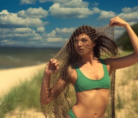Creative Beach Fashion Portrait — West Michigan Creative fashion portrait of woman in green bikini holding fishing net over face on west Michigan sand dunes