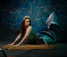 Creative Mermaid Concept Photography — Oakland County Michigan Moody mermaid concept fashion portrait of tattooed woman in shell crown green seashell top teal mermaid tail looking away Oakland County Michigan