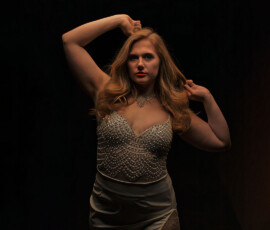 Metro Detroit Moody Studio Fashion Photography — Oakland County Michigan Dramatic studio fashion portrait of woman in crystal embellished dress arms raised against black background Oakland County Michigan
