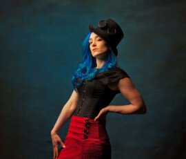 Oakland County Michigan Steampunk Concept Fashion Photography Steampunk concept fashion portrait of woman with blue hair in black corset red ruffled skirt and top hat with goggles Oakland County Michigan