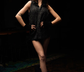 Detroit Metro Michigan Moody Dark Studio Fashion Photography — Charcoal Boucle Dress Shaggy Platform Boots Moody dark studio fashion portrait woman charcoal boucle zip dress fur collar fingerless gloves shaggy platform boots fluffy headband hands on hips botanical tattoo forearm mosaic tile floor Detroit Metro Michigan